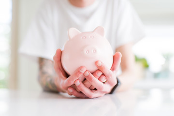 Close up of man holding piggy bank, saving money for investment