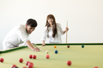 Couple dating and having fun playing snooker together in bar