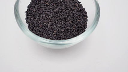 Black sesame seeds in a bowl on white background.It is asian food.