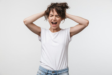 Image of shocked woman with short hair in basic t-shirt screaming and grabbing her head