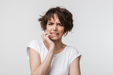 Portrait of upset woman with short brown hair in basic t-shirt frowning and looking at camera