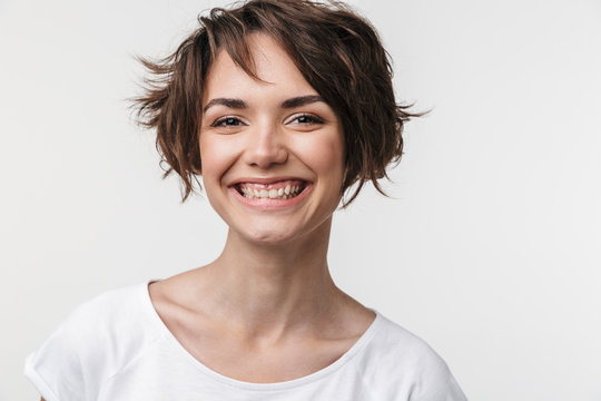 Portrait of kind woman with short brown hair in basic t-shirt smiling at camera