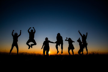 Fototapeta na wymiar Silhouettes group of people on mountain with sunset