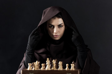 front view of woman in death costume with chess isolated on black