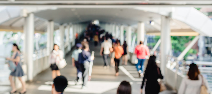 many people walking on the skywalk with blurry image, lifestyle in city