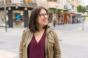 Obraz premium Beautiful young woman wearing glasses smiling confident at the streets of the town