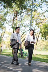 Business Couple talking outdoors and walking in a park