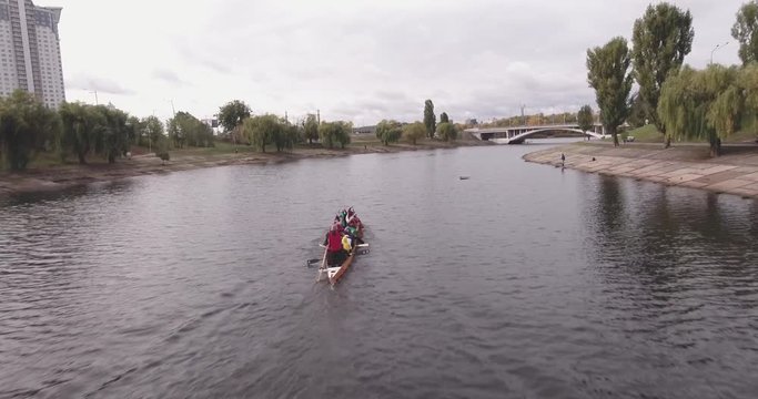 Aerial view of a young team of rowers exercising on the river. Top view of four athletes in a kayak. Training rowers on the river. Sporting Rowing Team Training. Rowing teams compete with each other. 