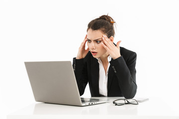 Photo of tense female worker businesswoman dressed in formal wear sitting at desk and working on laptop in office