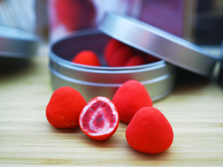 White chocolate covered crunchy strawberry with berry powder candies. Confectionery concept with selective focus.