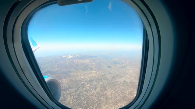 Aircraft window with the land shown from it