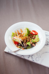 Fresh green mix salad with crispy crumb in white bowl