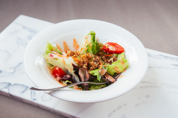 Fresh green mix salad with crispy crumb in white bowl