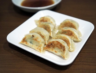 Deep fried gyoza plate served with dipping sauce. Selective focus.