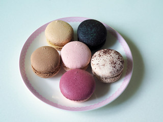 Delicious and colorful macaroon places on white plate with selective focus.