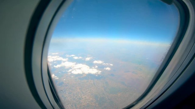 Clouds and land are shown from an aircraft