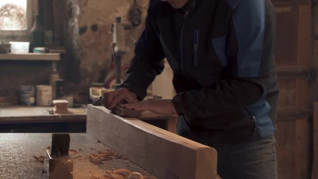 do it yourself enthusiast sanding wooden beam by hand
