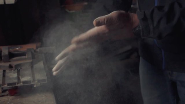 dusty hands of a worker in slowmotion