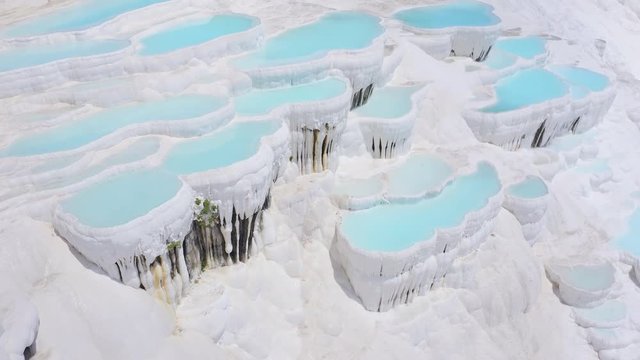Tilt shift of camera from travertines to tourists in Pamukkale, Turkey. Aerial footage 4k