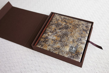 Photo book with a cover of genuine leather in the box. Brown color with decorative stamping. Opening box with photoalbum