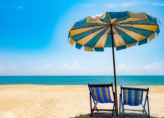 Beautiful scenery of two chairs and a white umbrella on the beach in summer. Copy area banner