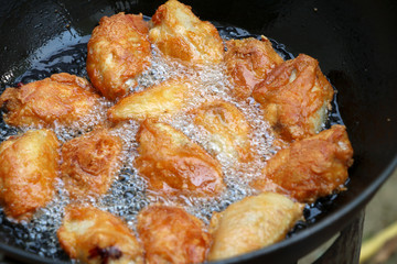 Fried chicken in a pan with hot oil. Golden yellow fried chicken in a pan.