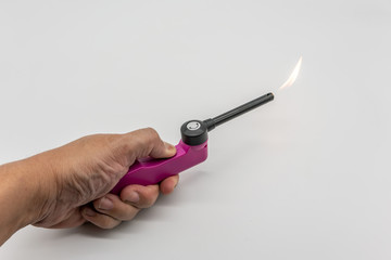 Hand holding Pnk and black lighter isolated on white