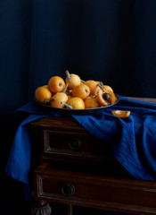 Still life with fresh medlar on the metallic plate