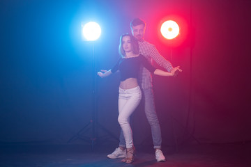 Fototapeta premium Social dance, kizomba and semba concept - young beautiful couple dancing bachata or salsa in the dark