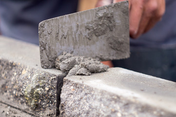 Builder puts brick, mortar on a trowel, construction work