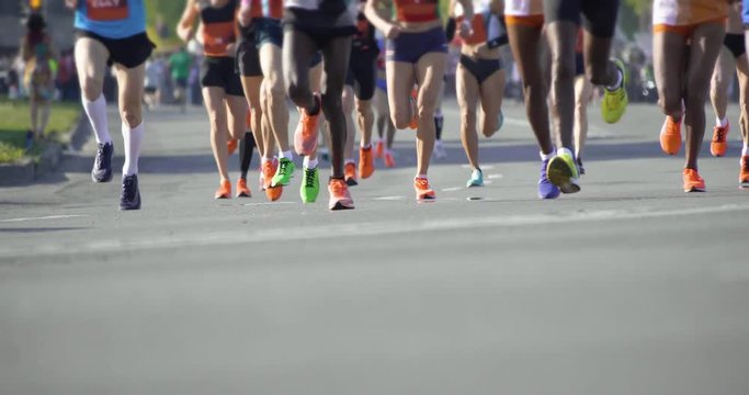 4K - A group of marathoners. Slow motion legs of athletes