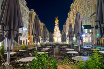Naklejka premium Nightscape of Graben street with street cafe and Plague Column, Austria, Vienna