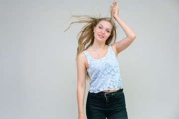 Life is beautiful and I like everything here. I am satisfied with life and I wish you. Portrait of a smiling beautiful blonde girl on a gray background in various poses.