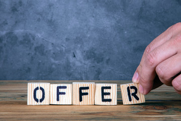 Offer - word from wooden letters on wooden table