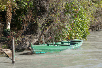 Fototapeta na wymiar Old wooden boat and river water near the shore in Georgia.