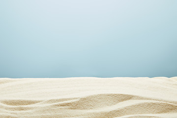 Fototapeta na wymiar wavy textured golden sand on blue background
