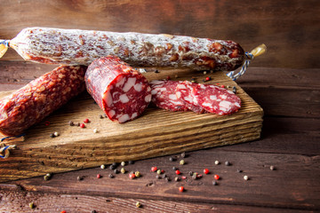 Traditional sausage and sausage with mold. Sliced sausage salami on wooden board with spices. Close-up.