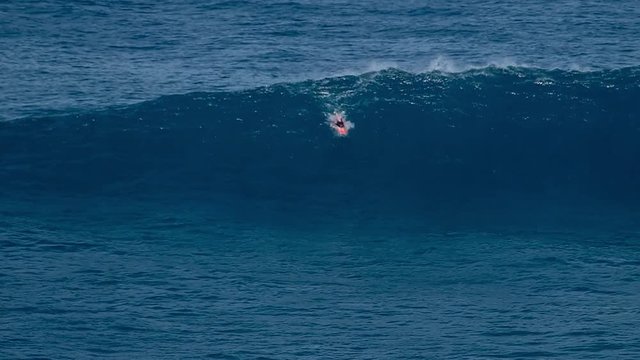 Surfer rides the giant wave at the famous Jaws (Peahi) surf spot in Maui, Hawaii