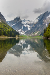 Obraz na płótnie Canvas lake Seealpsee, mirrored snowcapped mountain, clouds