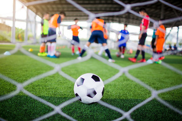 selective focus to football is in goal with blurry white mesh goal