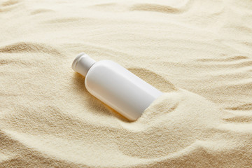 sunblock moisturizing lotion in white bottle in sand © LIGHTFIELD STUDIOS