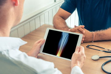 Doctor holding a digital tablet with x-ray-of leg of the patient. Ankle with pain