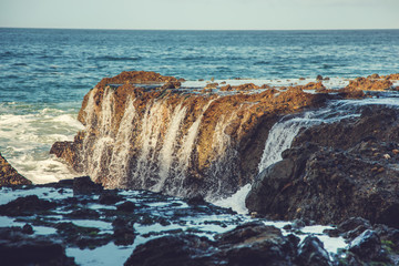 Wave waterfalls on rocky outcrops along the Pacific coast