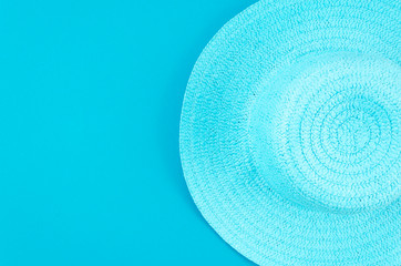 Fototapeta na wymiar Flat lay summer background. Women's summer straw hat on pastel blue background. Top view frame with copy space