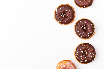 Yummy chocolate glazed assorted doughnuts on white background on the right side.Top view. Copy space