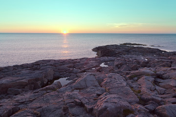 Fototapeta na wymiar Rocky beach on the shore of the Barents Sea at sunset
