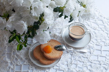 Apparecchiatura romantica del tavolo della colazione, con fiori di azalea bianca, tazza di caffè e...