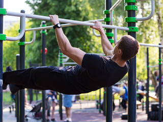 Fototapeta premium Male athlete performs exercises on the bar