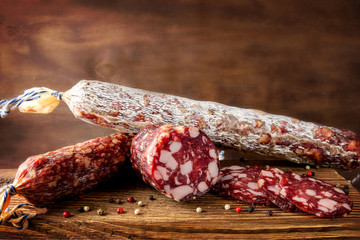 Traditional sausage and sausage with mold. Sliced sausage salami on wooden board with spices. Close-up.