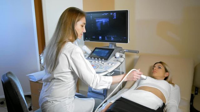 The doctor Taking A Sonogram to the patient to the woman